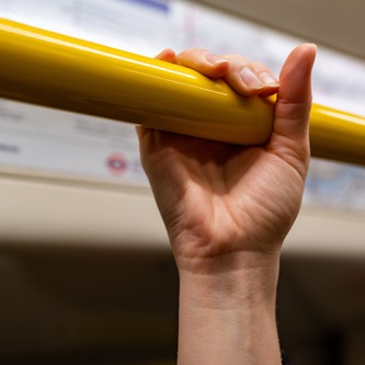 A hand holding on to the hand rail on the subway